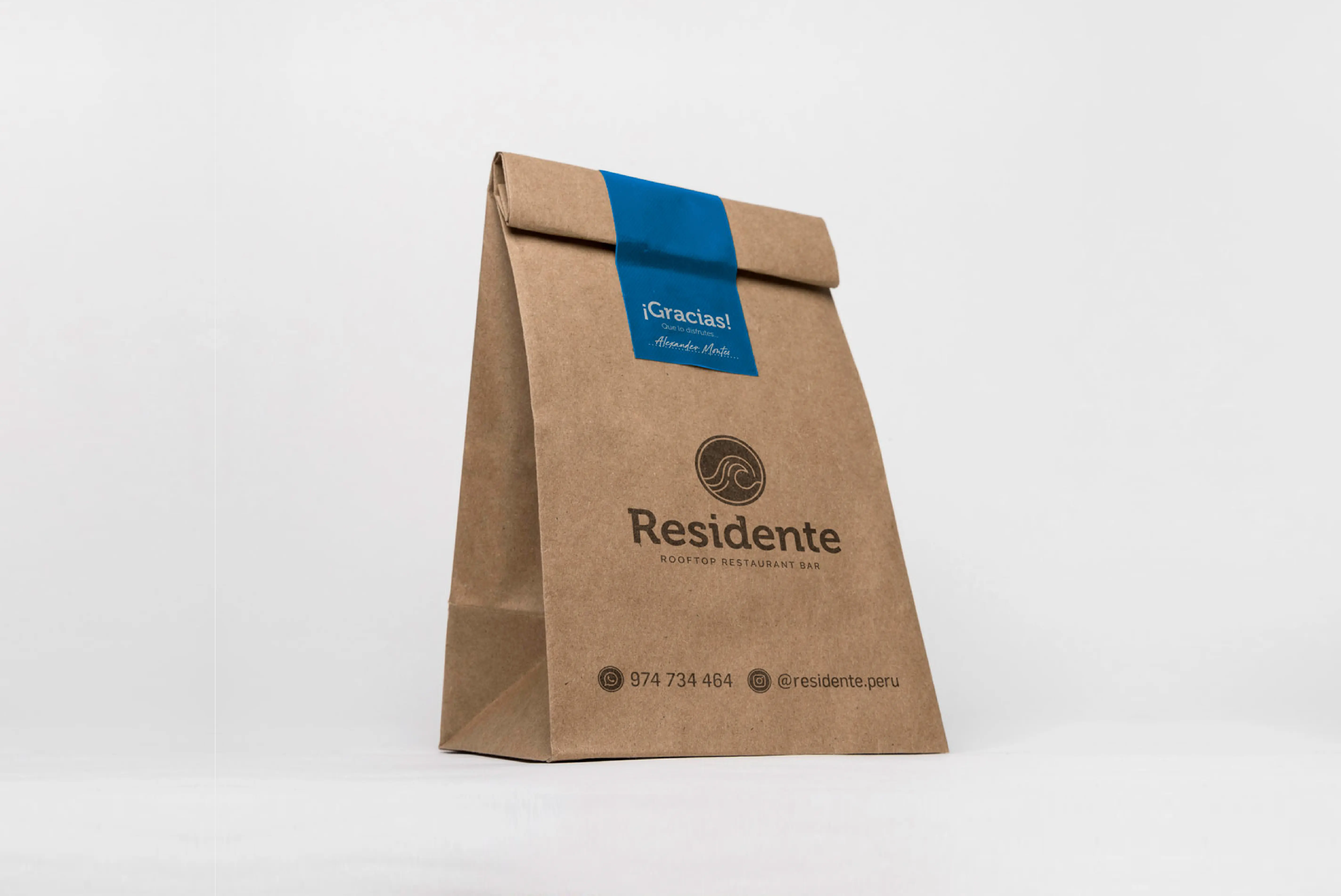 Bolsa de papel kraft para llevar de restaurantes con logotipo a un solo color más datos de contacto, con adhesivo de color azul para sellar.